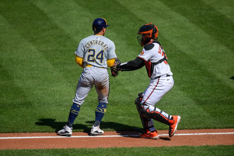 Apr 14, 2024; Baltimore, Maryland, USA; Baltimore Orioles catcher Adley Rutschman (35) tags Milwaukee Brewers catcher William Contreras (24) during the fifth inning at Oriole Park at Camden Yards. Mandatory Credit: Reggie Hildred-USA TODAY Sports