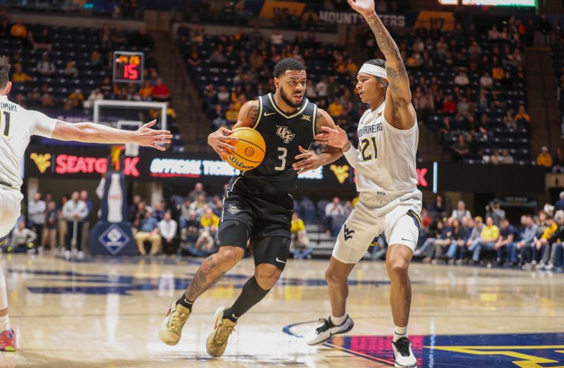 Feb 20, 2024; Morgantown, West Virginia, USA; UCF Knights guard Darius Johnson (3) drives down the lane against West Virginia Mountaineers guard RaeQuan Battle (21) during the first half at WVU Coliseum. Mandatory Credit: Ben Queen-USA TODAY Sports