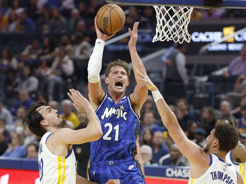 SAN FRANCISCO, CALIFORNIA - JANUARY 02: Moritz Wagner #21 of the Orlando Magic shoots over Klay Thompson #11 and Dario Saric #20 of the Golden State Warriors during the second quarter of an NBA basketball game at Chase Center on January 02, 2024 in San Francisco, California. NOTE TO USER: User expressly acknowledges and agrees that, by downloading and or using this photograph, User is consenting to the terms and conditions of the Getty Images License Agreement. (Photo by Thearon W. Henderson/Getty Images)