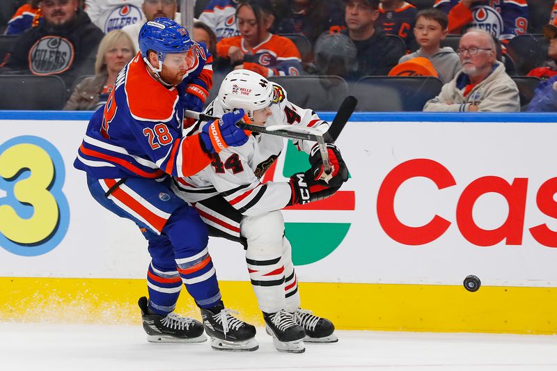 Oct 12, 2024; Edmonton, Alberta, CAN; Edmonton Oilers defensemen Brett Kulak (27)  and Chicago Blackhawks defensemen Wyatt Kaiser (44) battle for a loose puck  during the first period at Rogers Place. Mandatory Credit: Perry Nelson-Imagn Images