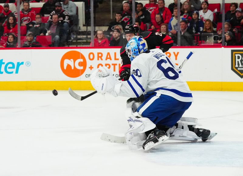 Mar 24, 2024; Raleigh, North Carolina, USA;  Toronto Maple Leafs goaltender Joseph Woll (60) makes a save in front of Carolina Hurricanes right wing Stefan Noesen (23) during the third period at PNC Arena. Mandatory Credit: James Guillory-USA TODAY Sports