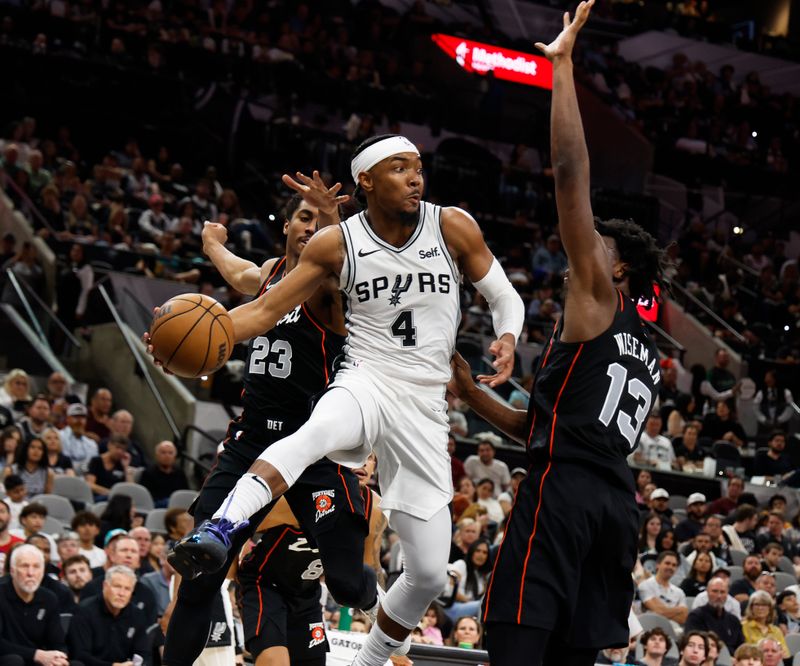 SAN ANTONIO, TX - APRIL 14:  Devonte Graham #4 of the San Antonio Spurs looks to pass around James Wiseman #13 of the Detroit Pistons in the second half at Frost Bank Center on April 14, 2024 in San Antonio, Texas. NOTE TO USER: User expressly acknowledges and agrees that, by downloading and or using this photograph, User is consenting to terms and conditions of the Getty Images License Agreement. (Photo by Ronald Cortes/Getty Images)