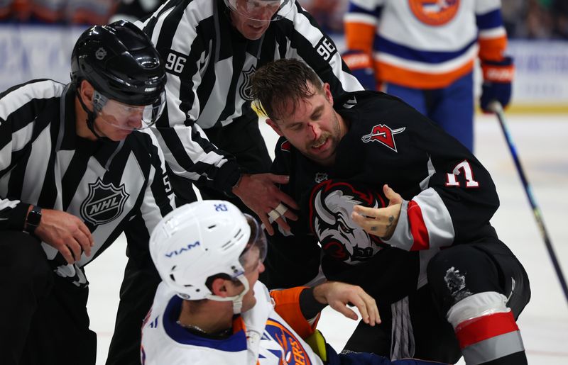 Nov 1, 2024; Buffalo, New York, USA;  Referees break up a fight between Buffalo Sabres left wing Jason Zucker (17) and New York Islanders right wing Oliver Wahlstrom (26) during the second period at KeyBank Center. Mandatory Credit: Timothy T. Ludwig-Imagn Images