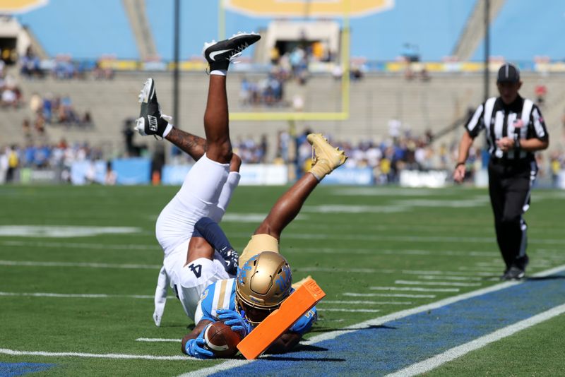 Oct 4, 2025; Pasadena, California, USA;  UCLA Bruins wide receiver Kwazi Gilmer (3) scores a touchdown against Penn State Nittany Lions cornerback AJ Harris (4) during the first quarter at Rose Bowl. Mandatory Credit: Kiyoshi Mio-Imagn Images