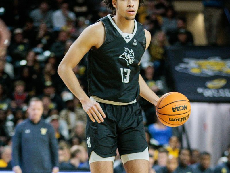 Mar 2, 2024; Wichita, Kansas, USA; Rice Owls forward Andrew Akuchie (13) brings the ball up court during the second half against the Wichita State Shockers  at Charles Koch Arena. Mandatory Credit: William Purnell-USA TODAY Sports