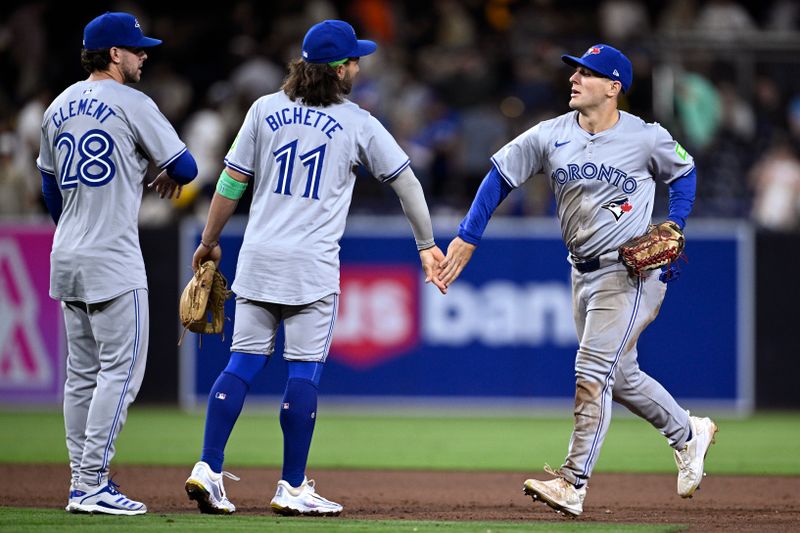 Apr 20, 2024; San Diego, California, USA; Toronto Blue Jays left fielder Daulton Varsho (right) celebrates on the field with shortstop Bo Bichette (11) and third baseman Ernie Clement (28) after defeating the San Diego Padres at Petco Park. Mandatory Credit: Orlando Ramirez-USA TODAY Sports