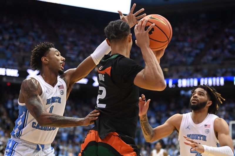 Feb 13, 2023; Chapel Hill, North Carolina, USA; Miami (Fl) Hurricanes guard Isaiah Wong (2) with the ball as North Carolina Tar Heels forward Leaky Black (1) and guard R.J. Davis (4) defend in the second half at Dean E. Smith Center. Mandatory Credit: Bob Donnan-USA TODAY Sports