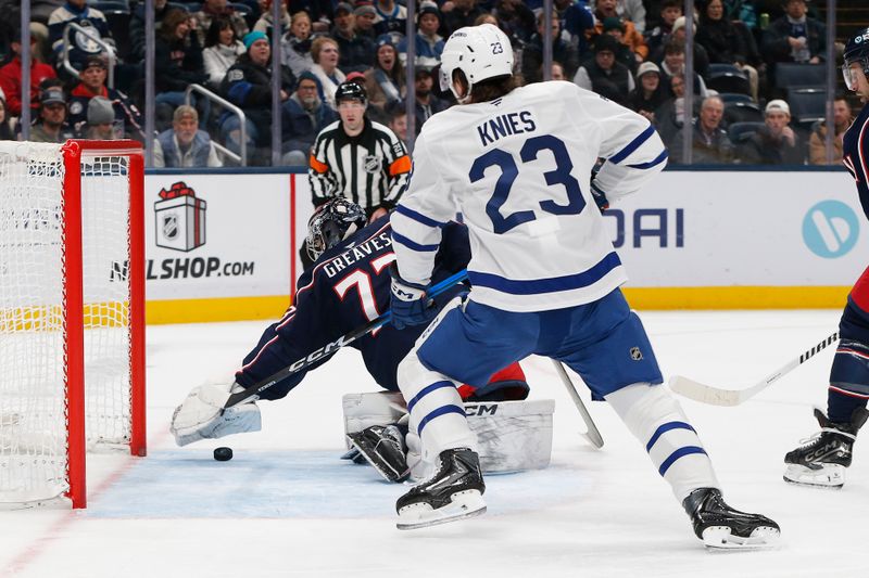Nov 26, 2025; Columbus, Ohio, USA; Columbus Blue Jackets goalie Jet Greaves (73) reaches to cover a loose puck in the crease as Toronto Maple Leafs left wing Matthew Knies (23) looks for a rebound during the first period at Nationwide Arena. Mandatory Credit: Russell LaBounty-Imagn Images