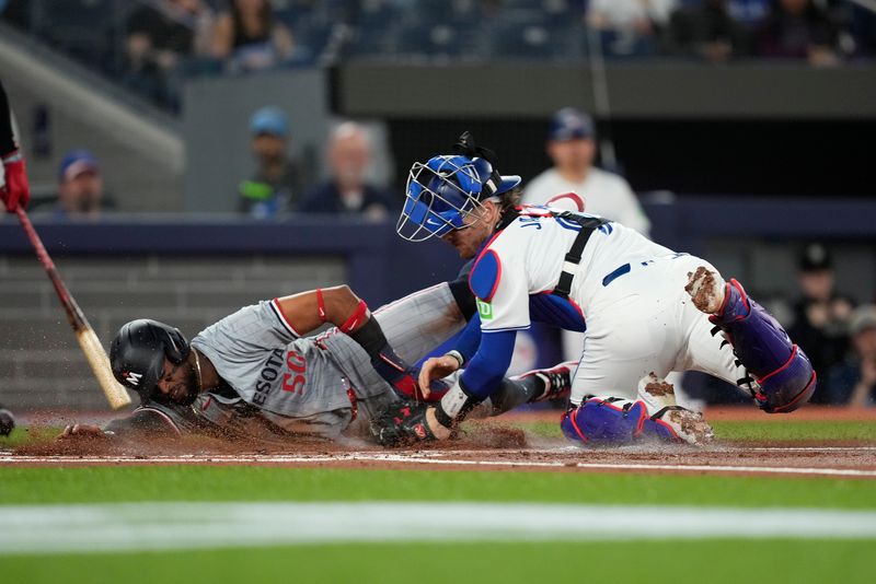 May 10, 2024; Toronto, Ontario, CAN; Toronto Blue Jays catcher Danny Jansen (9) tags out Minnesota Twins center fielder Willi Castro (50) trying to steal home during the first inning at Rogers Centre. Mandatory Credit: John E. Sokolowski-USA TODAY Sports