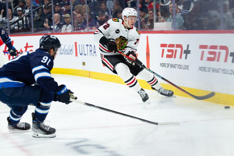 Jan 11, 2024; Winnipeg, Manitoba, CAN; Chicago Blackhawks defenseman Alex Vlasic (72) clears the puck past Winnipeg Jets forward Cole Perfetti (91) during the second period at Canada Life Centre. Mandatory Credit: Terrence Lee-USA TODAY Sports