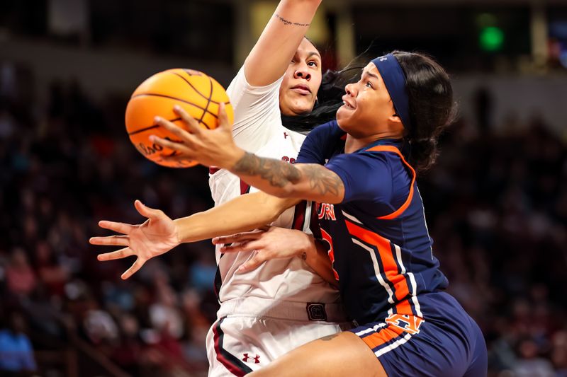 Jan 5, 2023; Columbia, South Carolina, USA; Auburn Tigers guard Mar'shaun Bostic (12) drives around South Carolina Gamecocks center Kamilla Cardoso (10) in the second half at Colonial Life Arena. Mandatory Credit: Jeff Blake-USA TODAY Sports