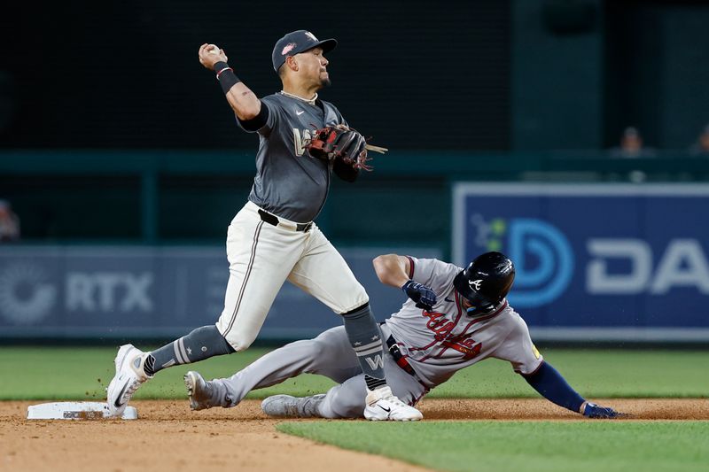 Jun 7, 2024; Washington, District of Columbia, USA; Washington Nationals second baseman Ildemaro Vargas (14) turns a double play at second base ahead of a slide by Atlanta Braves left fielder Adam Duvall (14) during the ninth inning at Nationals Park. Mandatory Credit: Geoff Burke-USA TODAY Sports