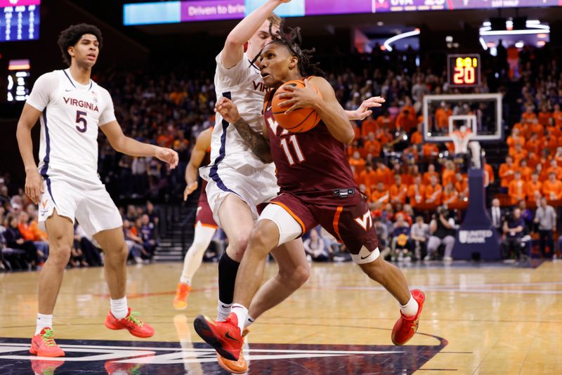 Feb 1, 2025; Charlottesville, Virginia, USA; Virginia Tech Hokies guard Ben Hammond (11) controls the ball as Virginia Cavaliers guard Andrew Rohde (4) defends in the first half at John Paul Jones Arena. Mandatory Credit: Amber Searls-Imagn Images