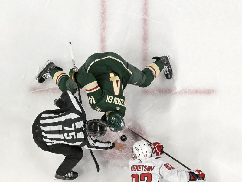 Jan 23, 2024; Saint Paul, Minnesota, USA;  Washington Capitals forward Evgeny Kuznetsov (92) and Minnesota Wild forward Joel Eriksson Ek (14) face-off during the third period at Xcel Energy Center. Mandatory Credit: Nick Wosika-USA TODAY Sports