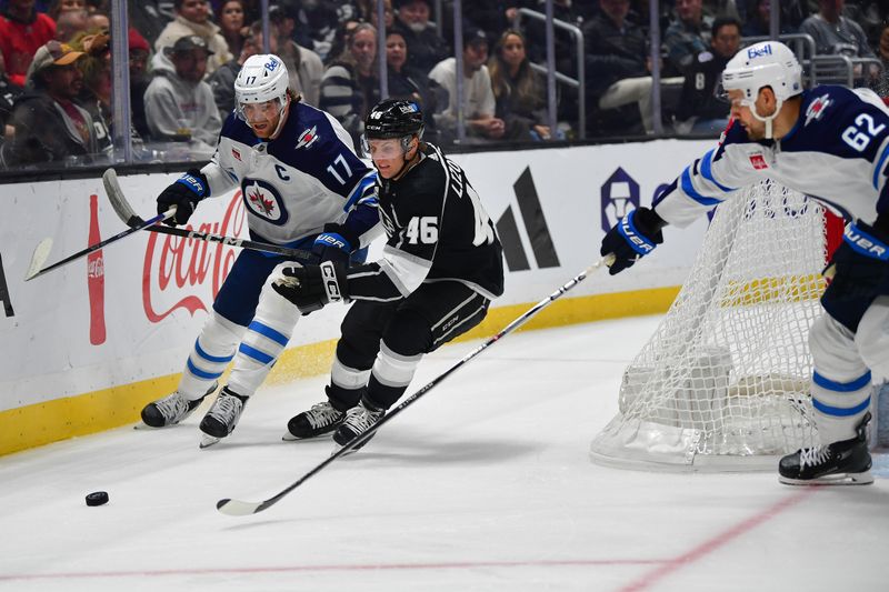 Dec 13, 2023; Los Angeles, California, USA; Los Angeles Kings center Blake Lizotte (46) plays for the puck against Winnipeg Jets center Adam Lowry (17) and right wing Nino Niederreiter (62) during the first period at Crypto.com Arena. Mandatory Credit: Gary A. Vasquez-USA TODAY Sports