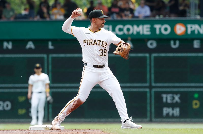 May 23, 2024; Pittsburgh, Pennsylvania, USA; Pittsburgh Pirates second baseman Nick Gonzales (39) throws to first base to complete a double play against the San Francisco Giants during the second inning at PNC Park. Mandatory Credit: Charles LeClaire-USA TODAY Sports