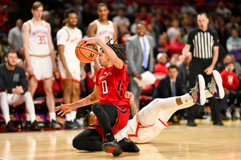 Feb 6, 2024; College Park, Maryland, USA; Rutgers Scarlet Knights guard Derek Simpson (0) is tackled by Maryland Terrapins guard DeShawn Harris-Smith (5) along there sidelines during the second half  at Xfinity Center. Mandatory Credit: Tommy Gilligan-USA TODAY Sports