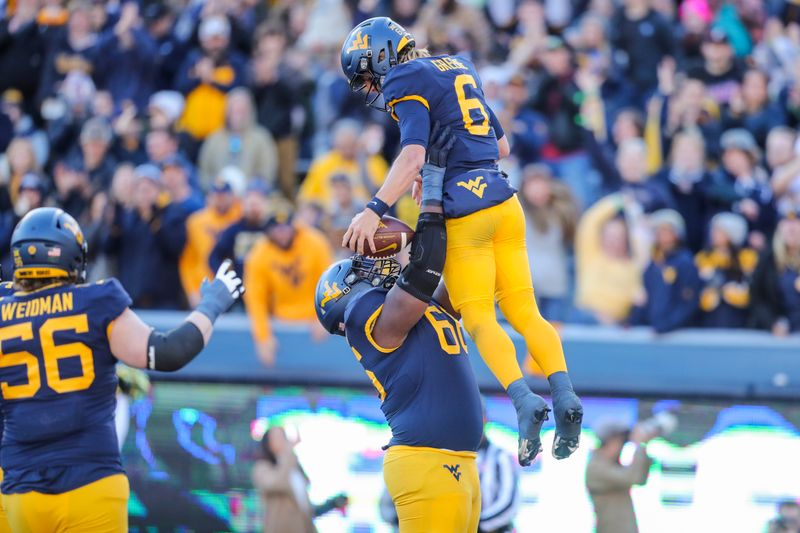 Nov 18, 2023; Morgantown, West Virginia, USA; West Virginia Mountaineers quarterback Garrett Greene (6) celebrates after running the ball for a touchdown during the first quarter against the Cincinnati Bearcats at Mountaineer Field at Milan Puskar Stadium. Mandatory Credit: Ben Queen-USA TODAY Sports