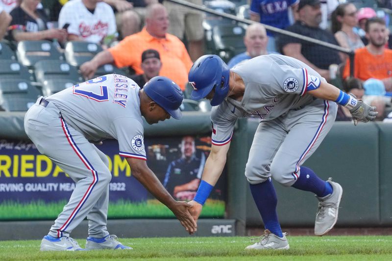 Jun 25, 2025; Baltimore, Maryland, USA; Texas Rangers third baseman Josh Jung (right) celebrates with coach Tony Beasley (left) following his fourth inning two run home run against the Baltimore Orioles at Oriole Park at Camden Yards. Mandatory Credit: Mitch Stringer-Imagn Images