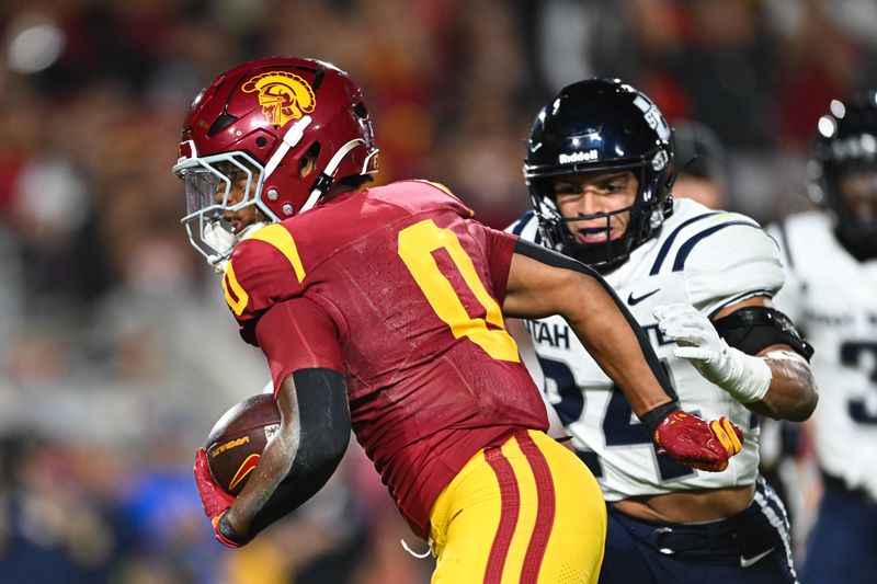 Sep 7, 2024; Los Angeles, California, USA; USC Trojans running back Quinten Joyner (0) scores a touchdown against Utah State Aggies safety Jordan Vincent (24) during the first quarter at United Airlines Field at Los Angeles Memorial Coliseum. Mandatory Credit: Jonathan Hui-Imagn Images