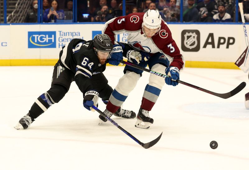 Feb 15, 2024; Tampa, Florida, USA; Tampa Bay Lightning center Tyler Motte (64) and Colorado Avalanche defenseman Jack Johnson (3) go after the loose puck during the first period at Amalie Arena. Mandatory Credit: Kim Klement Neitzel-USA TODAY Sports