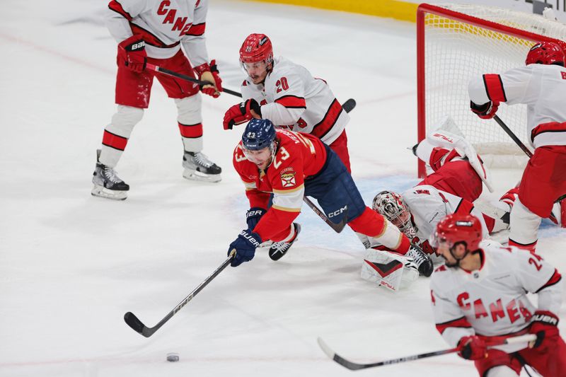 May 24, 2025; Sunrise, Florida, USA; Florida Panthers center Carter Verhaeghe (23) goes for the puck as Carolina Hurricanes center Sebastian Aho (20) defends during the second period in game three of the Eastern Conference Final of the 2025 Stanley Cup Playoffs at Amerant Bank Arena. Mandatory Credit: Sam Navarro-Imagn Images