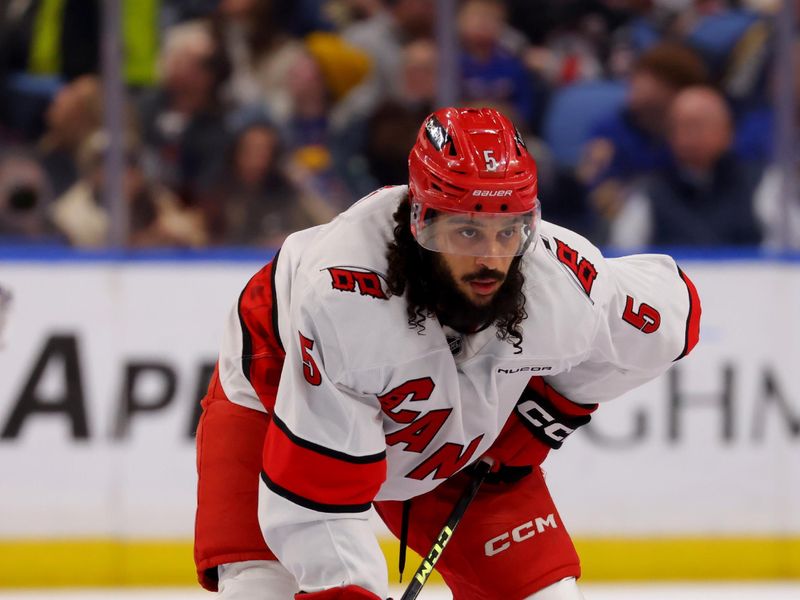 Apr 8, 2025; Buffalo, New York, USA;  Carolina Hurricanes defenseman Jalen Chatfield (5) waits for the face-off during the first period against the Buffalo Sabres at KeyBank Center. Mandatory Credit: Timothy T. Ludwig-Imagn Images
