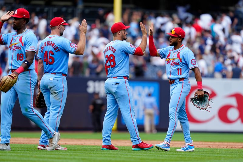 Aug 31, 2024; Bronx, New York, USA; St. Louis Cardinals first baseman Paul Goldschmidt (46) and third baseman Nolan Arenado (28) and center fielder Victor Scott II (11) slap hands to celebrate the victory against the New York Yankees after the ninth inning at Yankee Stadium. Mandatory Credit: Gregory Fisher-USA TODAY Sports