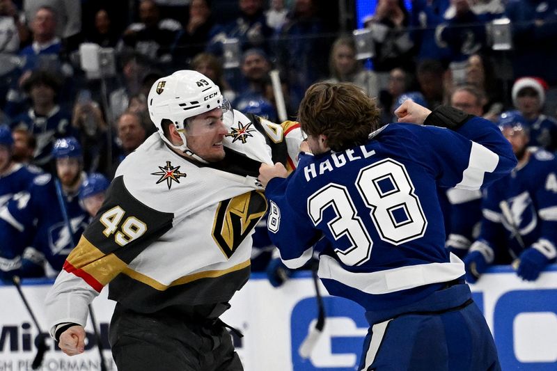 Dec 21, 2023; Tampa, Florida, USA; Tampa Bay Lightning left wing Brandon Hagel (38) and  Las Vegas Golden Knights center Ivan Barbashev (49) fight in the second period at Amalie Arena. Mandatory Credit: Jonathan Dyer-USA TODAY Sports