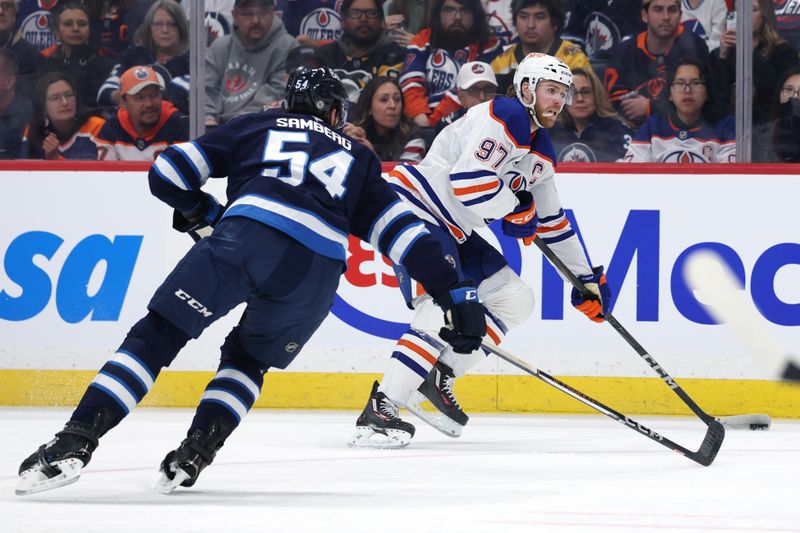 Apr 13, 2025; Winnipeg, Manitoba, CAN; Edmonton Oilers center Connor McDavid (97) eludes Winnipeg Jets defenseman Dylan Samberg (54) in the first period at Canada Life Centre. Mandatory Credit: James Carey Lauder-Imagn Images
