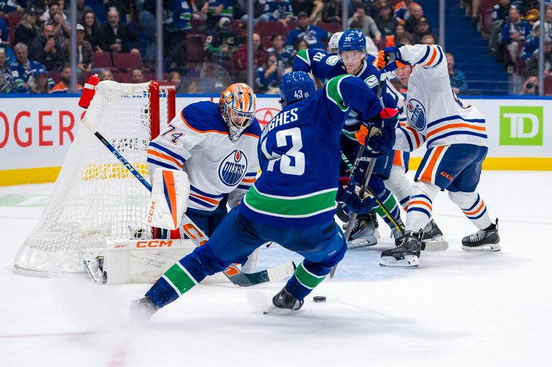 Oct 4, 2024; Vancouver, British Columbia, CAN; Edmonton Oilers goalie Stuart Skinner (74) makes a save on Vancouver Canucks defenseman Quinn Hughes (43) during the third period at Rogers Arena. Mandatory Credit: Bob Frid-Imagn Images