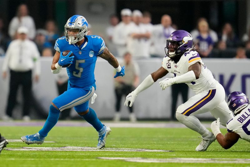 Detroit Lions running back David Montgomery (5) runs from Minnesota Vikings safety Josh Metellus (44) during the first half of an NFL football game, Sunday, Dec. 24, 2023, in Minneapolis. (AP Photo/Abbie Parr)