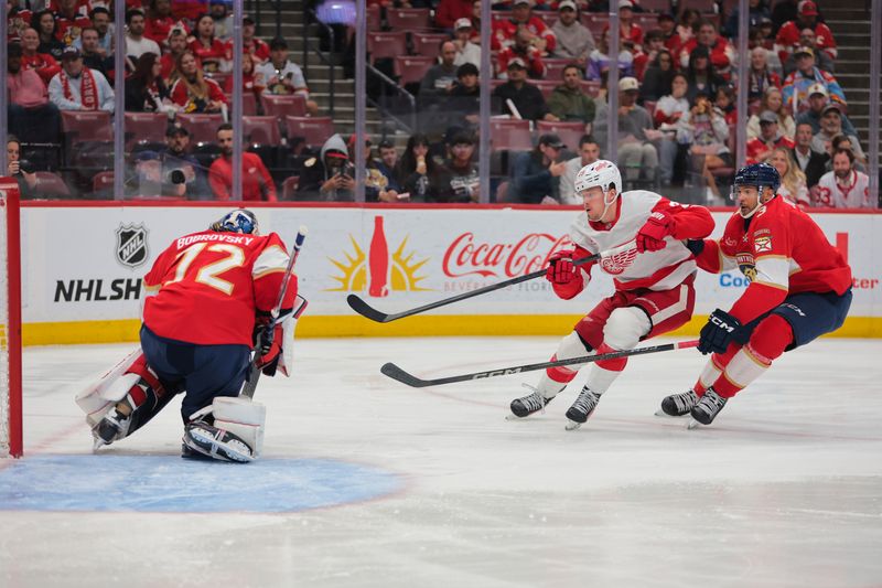 Apr 10, 2025; Sunrise, Florida, USA; Detroit Red Wings left wing Lucas Raymond (23) shoots the puck past Florida Panthers defenseman Seth Jones (3) but cannot score against Florida Panthers goaltender Sergei Bobrovsky (72) during the second period at Amerant Bank Arena. Mandatory Credit: Sam Navarro-Imagn Images