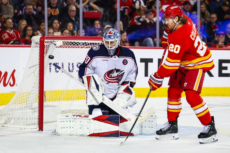Dec 3, 2024; Calgary, Alberta, CAN; Calgary Flames defenseman Rasmus Andersson (not pictured) scores a goal against Columbus Blue Jackets goaltender Elvis Merzlikins (90) as Calgary Flames center Blake Coleman (20) screens in front during the second period at Scotiabank Saddledome. Mandatory Credit: Sergei Belski-Imagn Images