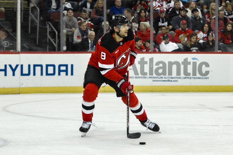 Oct 19, 2024; Newark, New Jersey, USA; New Jersey Devils defenseman Johnathan Kovacevic (8) skates with the puck against Washington Capitals during the first period at Prudential Center. Mandatory Credit: John Jones-Imagn Images