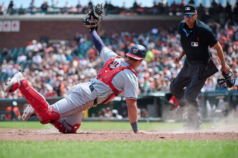 Apr 10, 2024; San Francisco, California, USA; Washington Nationals catcher Drew Millas (81) shows the ball to home plate umpire Chad Fairchild (4) after tagging a San Francisco Giants baserunner out at home plate during the sixth inning at Oracle Park. Mandatory Credit: Robert Edwards-USA TODAY Sports