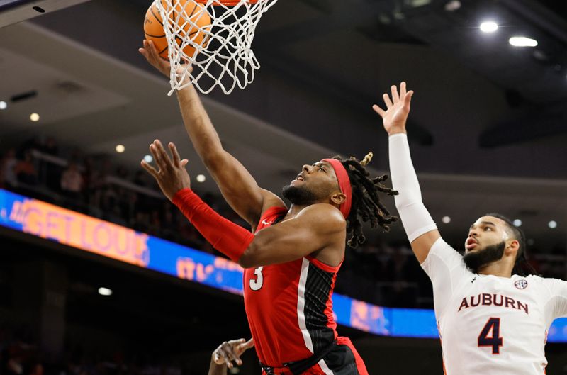 Feb 1, 2023; Auburn, Alabama, USA;  Georgia Bulldogs guard Kario Oquendo (3) goes for a shot around Auburn Tigers forward Johni Broome (4) during the first half at Neville Arena. Mandatory Credit: John Reed-USA TODAY Sports