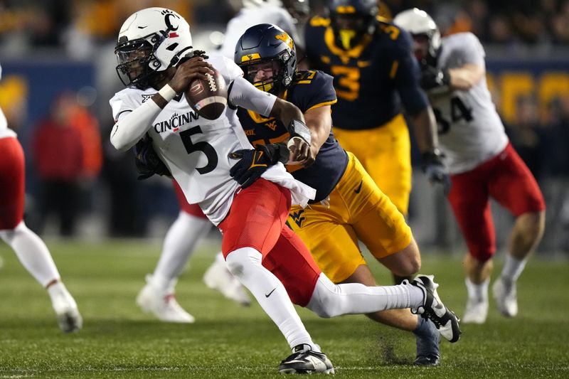 Nov 18, 2023; Morgantown, West Virginia, USA; Cincinnati Bearcats quarterback Emory Jones (5) attempts to evade pressure by West Virginia Mountaineers linebacker Ben Cutter (15) in the fourth quarter at Milan Puskar Stadium. West Virginia won 42-21. Mandatory Credit: Kareem Elgazzar-USA TODAY Sports