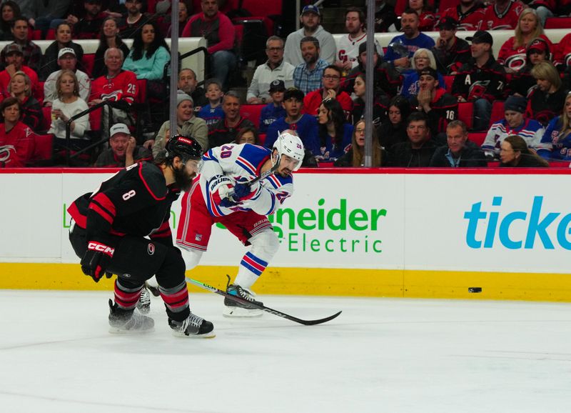 Mar 12, 2024; Raleigh, North Carolina, USA; New York Rangers left wing Chris Kreider (20) gets the shot past Carolina Hurricanes defenseman Brent Burns (8) during the second period at PNC Arena. Mandatory Credit: James Guillory-USA TODAY Sports