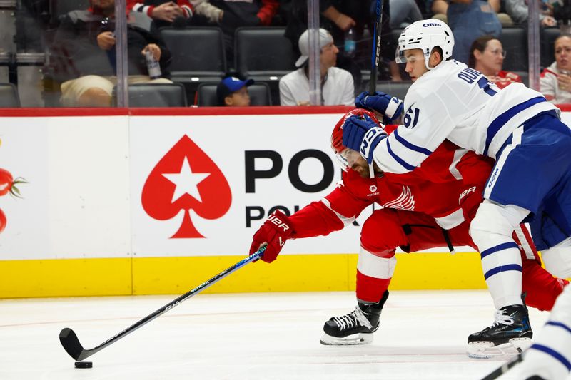 Oct 3, 2024; Detroit, Michigan, USA;  Detroit Red Wings center Tyler Motte (14) skates with the puck defended by Toronto Maple Leafs center Jacob Quillan (61) in the second period at Little Caesars Arena. Mandatory Credit: Rick Osentoski-Imagn Images