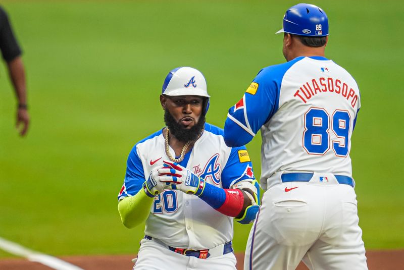 Jul 6, 2024; Cumberland, Georgia, USA; Atlanta Braves designated hitter Marcell Ozuna (20) reacts with third base coach Matt Tuiasosopo (89) after hitting a home run against the Philadelphia Phillies during the first inning at Truist Park. Mandatory Credit: Dale Zanine-USA TODAY Sports