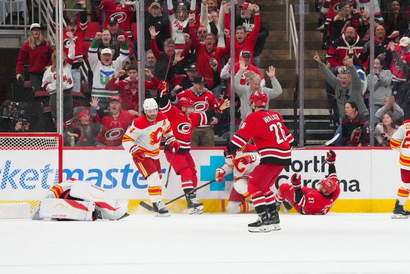 Nov 30, 2025; Raleigh, North Carolina, USA;  Carolina Hurricanes left wing Nikolaj Ehlers (27) celebrates his game-winner in the overtime with left wing Taylor Hall (71) against Calgary Flames goaltender Devin Cooley (1) defenseman Rasmus Andersson (4) and center Nazem Kadri (91) at Lenovo Center. Mandatory Credit: James Guillory-Imagn Images