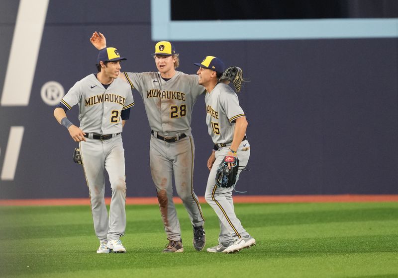 May 31, 2023; Toronto, Ontario, CAN; Milwaukee Brewers left fielder Christian Yelich (22), center fielder Joey Wiemer (28) and right fielder Tyrone Taylor (15) celebrate a win against the Toronto Blue Jays at Rogers Centre. Mandatory Credit: Nick Turchiaro-USA TODAY Sports