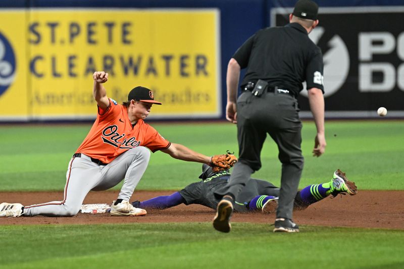 Aug 10, 2024; St. Petersburg, Florida, USA; Baltimore Orioles second baseman Jackson Holliday (7) drops the ball as Tampa Bay Rays short stop Jose Caballero (7) slides into second base in the fifth inning  at Tropicana Field. Mandatory Credit: Jonathan Dyer-USA TODAY Sports