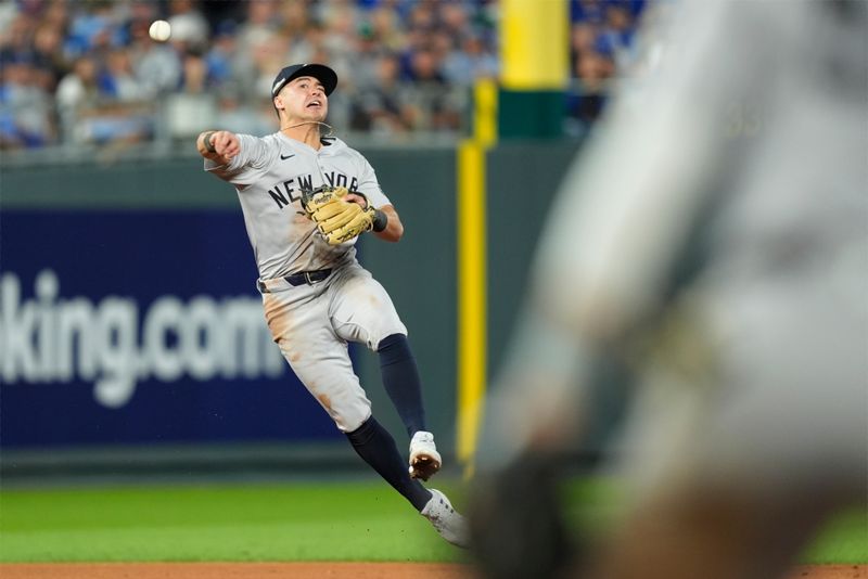 Oct 9, 2024; Kansas City, Missouri, USA; New York Yankees shortstop Anthony Volpe (11) throws to first base in the fifth inning against the Kansas City Royals during game three of the NLDS for the 2024 MLB Playoffs at Kauffman Stadium. Mandatory Credit: Jay Biggerstaff -Imagn Images