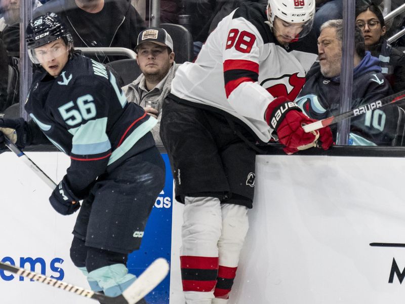 Dec 7, 2023; Seattle, Washington, USA; Seattle Kraken forward Kailer Yamamoto (56) and defenseman Kevin Bahl (88) battle for the puck during the second period at Climate Pledge Arena. Mandatory Credit: Stephen Brashear-USA TODAY Sports