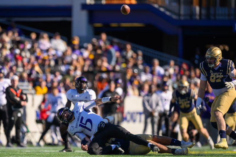 Nov 18, 2023; Annapolis, Maryland, USA; East Carolina Pirates quarterback Alex Flinn (15) fumbles the ball while being tackled during the second quarter against the Navy Midshipmen at Navy-Marine Corps Memorial Stadium. Mandatory Credit: Reggie Hildred-USA TODAY Sports