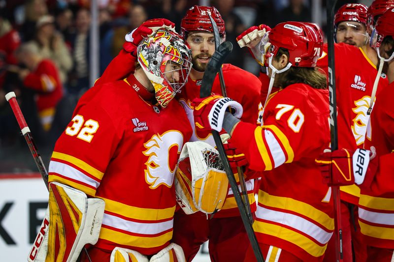 Jan 17, 2026; Calgary, Alberta, CAN; Calgary Flames goaltender Dustin Wolf (32) celebrates win with teammates after defeating New York Islanders at Scotiabank Saddledome. Mandatory Credit: Sergei Belski-Imagn Images