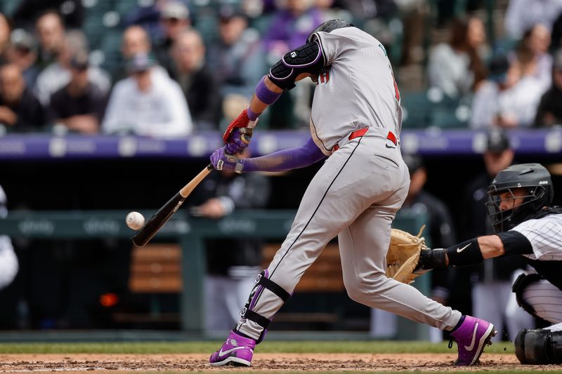 Apr 10, 2024; Denver, Colorado, USA; Arizona Diamondbacks left fielder Lourdes Gurriel Jr. (12) hits an RBI double in the seventh inning against the Colorado Rockies at Coors Field. Mandatory Credit: Isaiah J. Downing-USA TODAY Sports