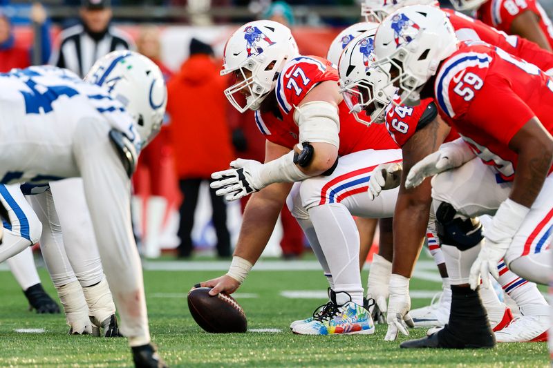 New England Patriots center Ben Brown (77) prepares to hike the ball at the line of scrimmage wearing colorful cleats during the second half of an NFL football game against the Indianapolis Colts, Sunday, Dec. 1, 2024, in Foxborough, Mass. The Indianapolis Colts won 25-24. (AP Photo/Greg M. Cooper)